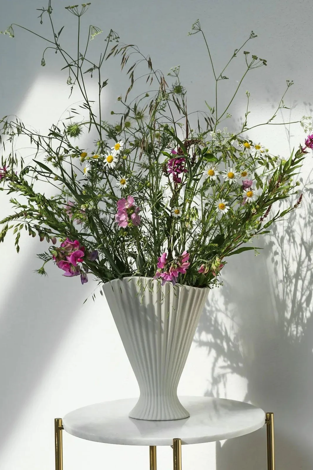 Auf dem Beistelltisch von @houseandermosel steht die hohe Fountain Vase von Ferm Living mit vielen Frühlingsblumen.