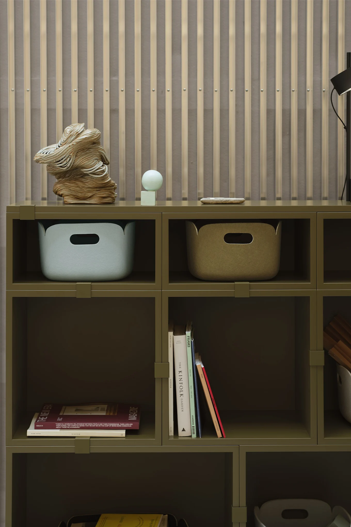 Ein grünes Regal mit Aufbewahrungsboxen und Büchern als Details, ganz im Einklang mit den Wohntrends 2026.