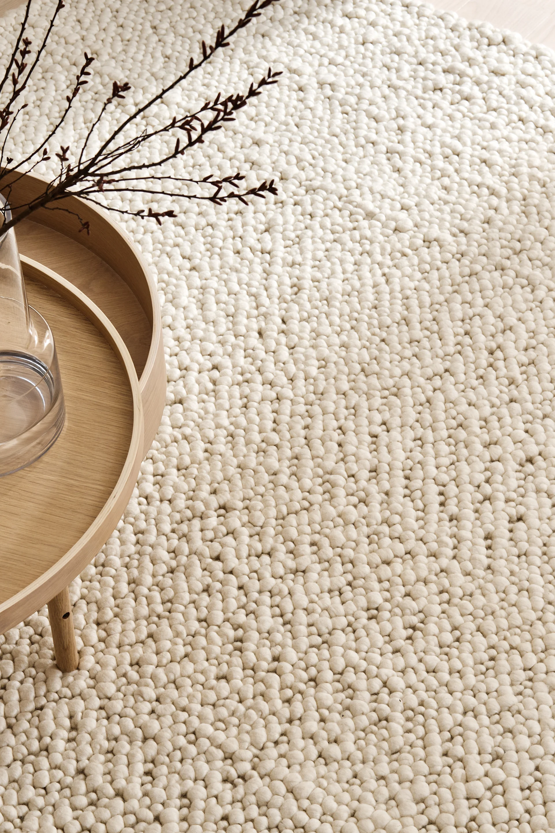 Wohnzimmer beige: Der beigefarbene Mire Teppich von Scandi Living liegt unter einem Couchtisch aus hellem Holz.