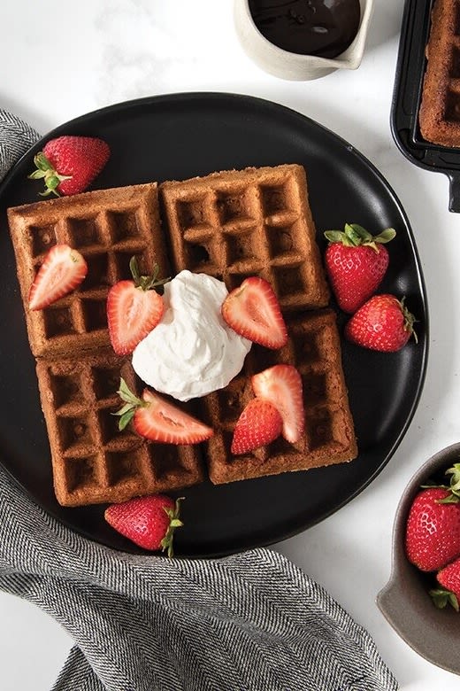 Valentinstag zu Hause: Backen Sie belgische Waffeln mit Schokolade, Erdbeeren und Sahne für Ihren Partner zum Valentinstag.