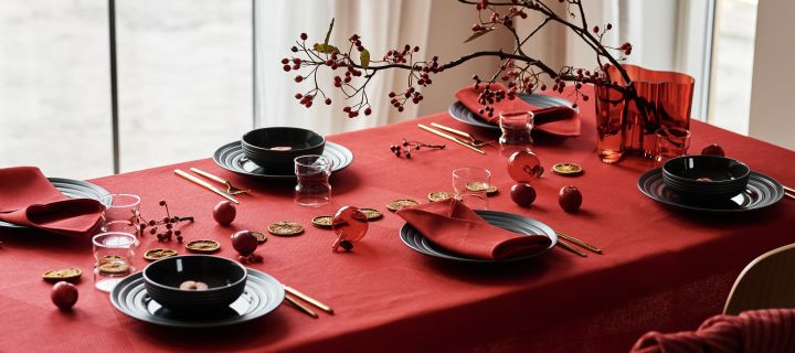 Tischgedeck mit dunkelgrauem Lines-Porzellan von NJRD, rote Leinenservietten und rote Leinentischdecke von NJRD für einen festlich gedeckten Weihnachtstisch.