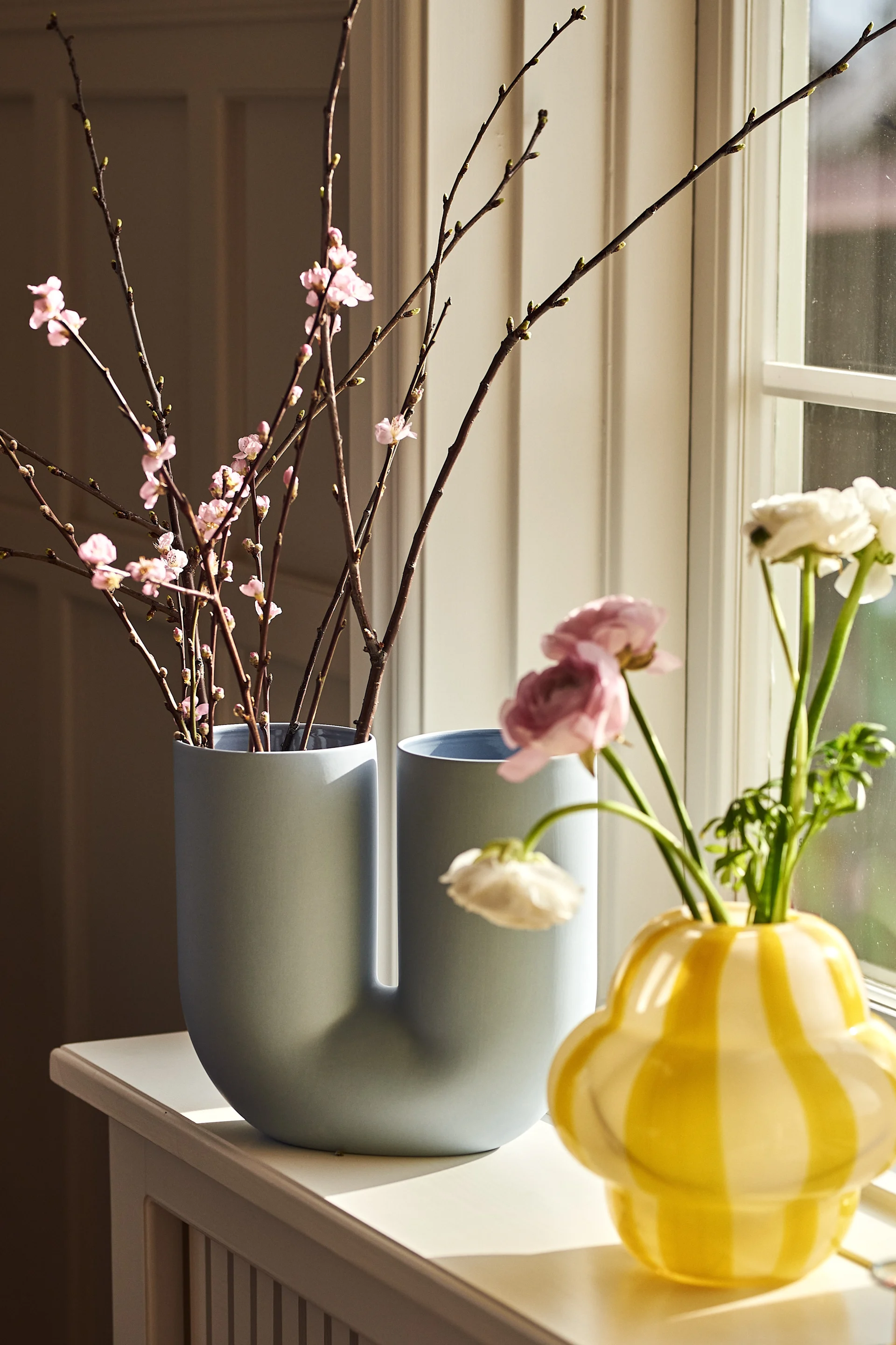 Bringen Sie Pastellfarben in Ihr Interieur, indem Sie die blaue Kink Vase von Muuto zusammen mit der gelben Curlie Vase von By On dekorieren.