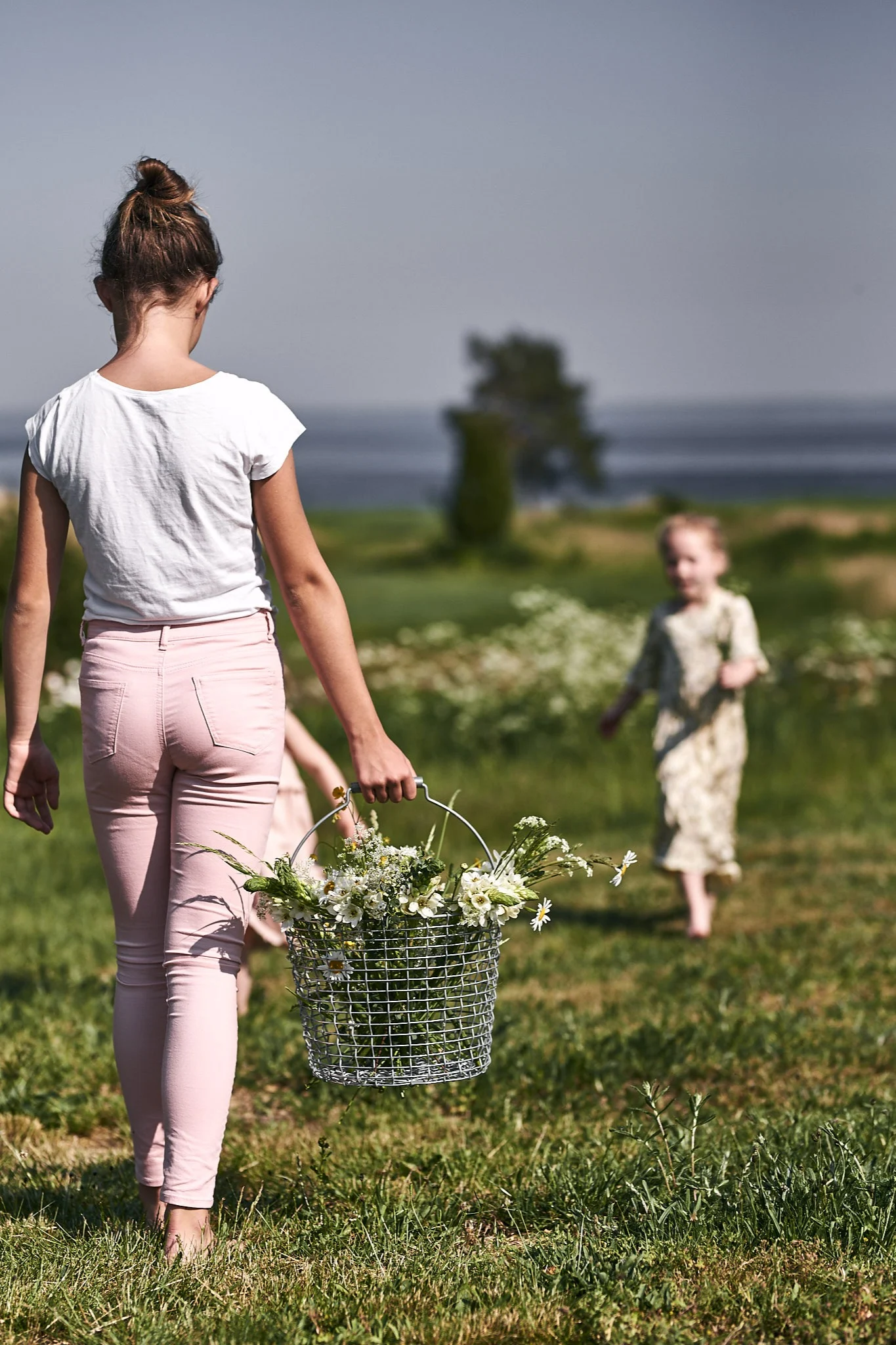 Kinder pflücken Wildblumen auf der Wiese, um für das Gartenfest Blumenarrangements zu gestalten. 