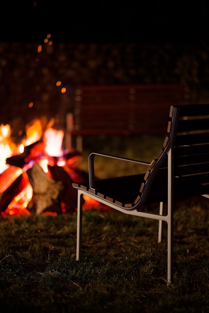 Ein gemütliches Lagerfeuer zu machen sollte auf Ihrer Herbst To-do-Liste ganz weit oben stehen. Hier auf dem Bild steht der Traverse Lounge-Armlehnenstuhl von HAY vor einem Lagerfeuer.