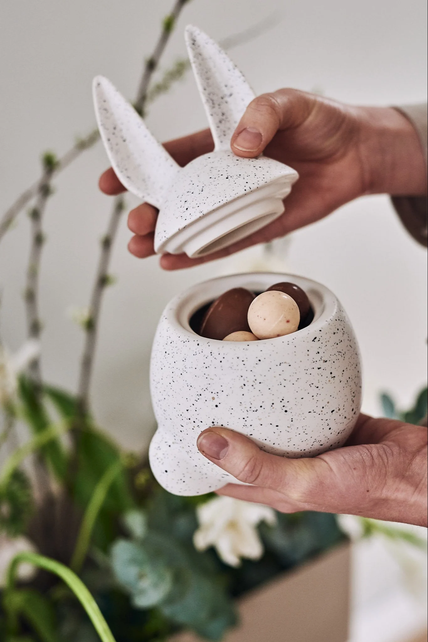 Tipps zur Ostereiersuche für Kinder mit einem Schild, das den Weg zu einem mit Süßigkeiten gefüllten Ei auf der Treppe weist.