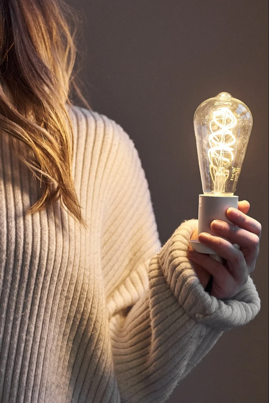 Eine Glühbirne in der Hand einer Frau.