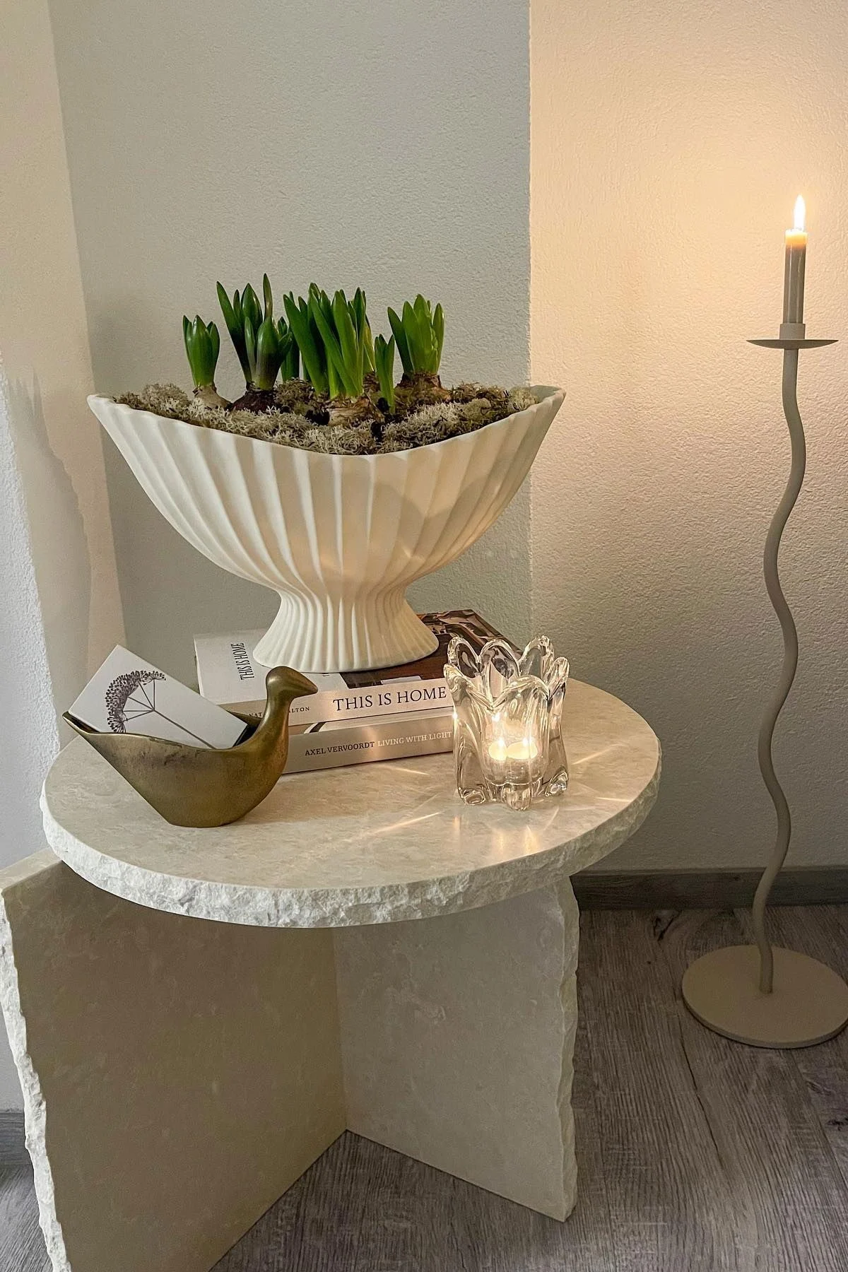Der Mineral Sculptural Tisch ist dekoriert mit der Fountain Schale, beides von Ferm Living, und weiteren Kleinigkeiten. Daneben steht der große Curved Kerzenhalter von Cooee Design.