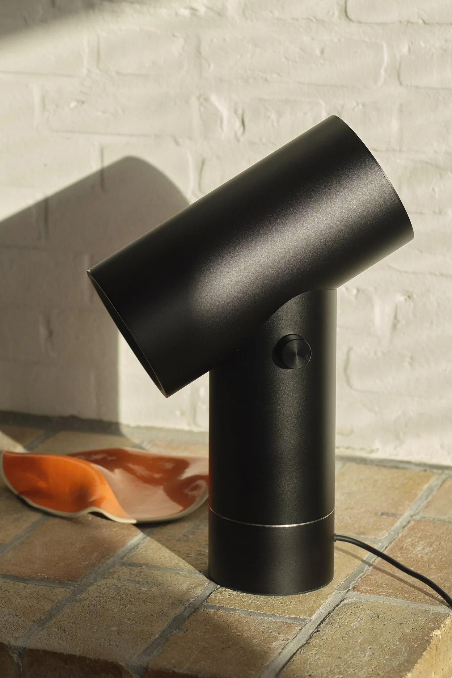 Die schwarze Beam Tischleuchte von Muuto in einer gekachelten Umgebung.