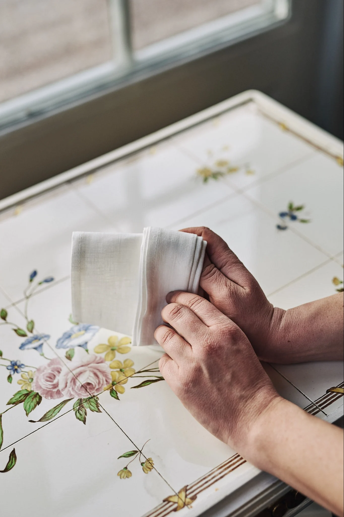 Serviettenfaltung mit weißer Leinenserviette in Form eines Fächers.