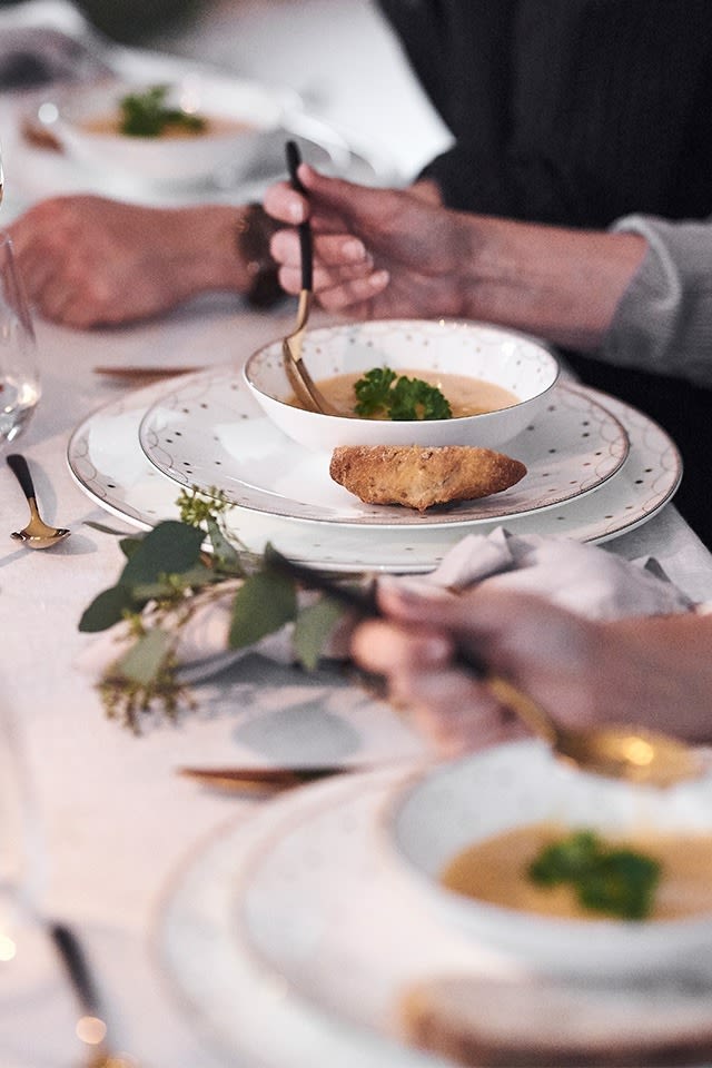Weihnachtlich gedeckter Tisch in Weiß mit Teller und Schale aus der Serie Julemorgen von Wik & Walsøe. 