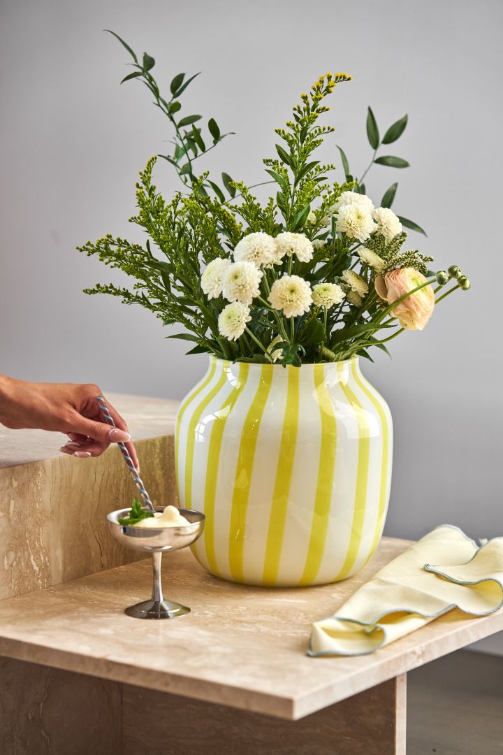 Die Einrichtungstrends des Frühlings 2023 sind von Farben geprägt, von auffälligen Vasen und einer festlichen Atmosphäre. Wir dekorieren gern mit der gelb gestreiften Vase und Dessertschälchen von HAY.