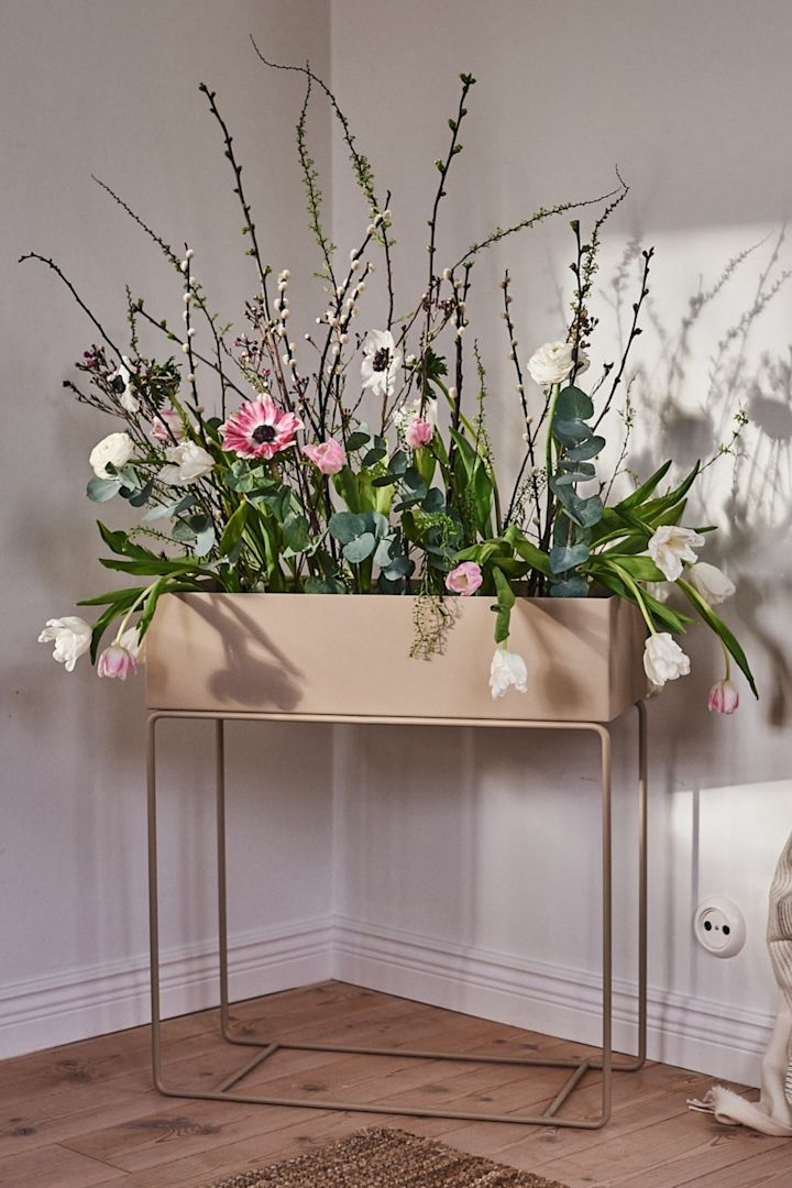 Frühlingserwachen: Hier sehen Sie ein wunderschönes Arrangement frischer Blumen, das wie ein Indoor-Blumenbeet in der kultigen Pflanzbox von ferm LIVING aussieht.