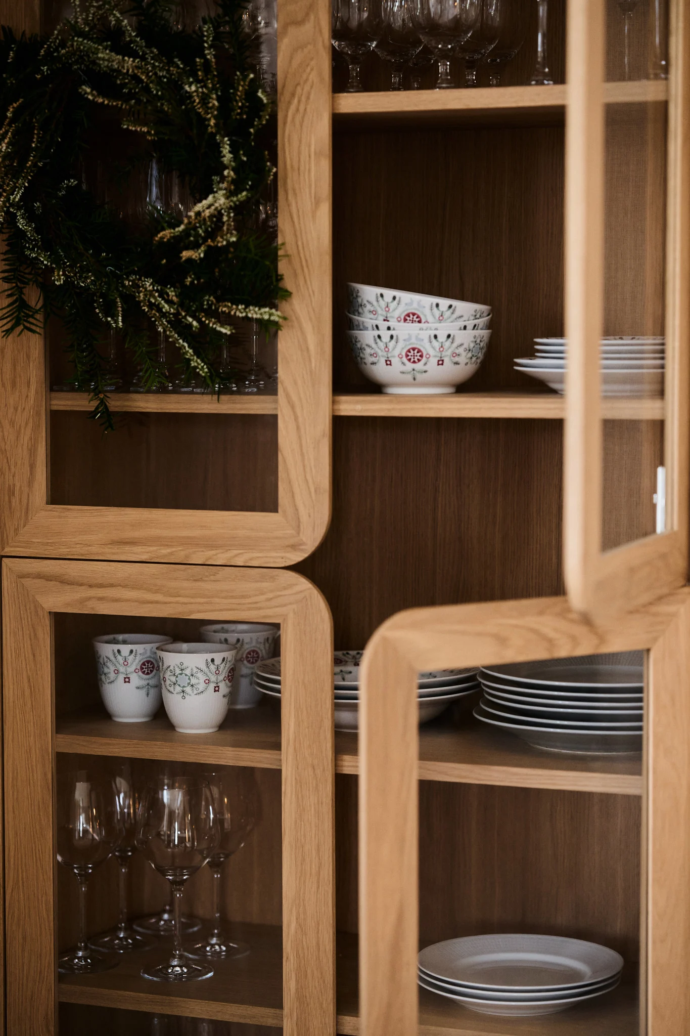 Weihnachtsgeschirr, wie das aus der Swedish Grace Winter-Kollektion von Rörstrand ist ein Muss für jede Weihnachtsfeier. Hier sehen Sie das Geschirr in einem Vitrinenschrank stehen.