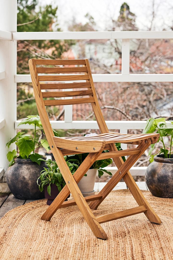 Balkon Ideen: Nutzen Sie platzsparende Möbel für Ihren Balkon, beispielsweise den Klappstuhl Aneboda von 1898 aus Teakholz, der perfekt auf einen kleinen Balkon passt, da er wenig Platz braucht und zusammengeklappt werden kann.