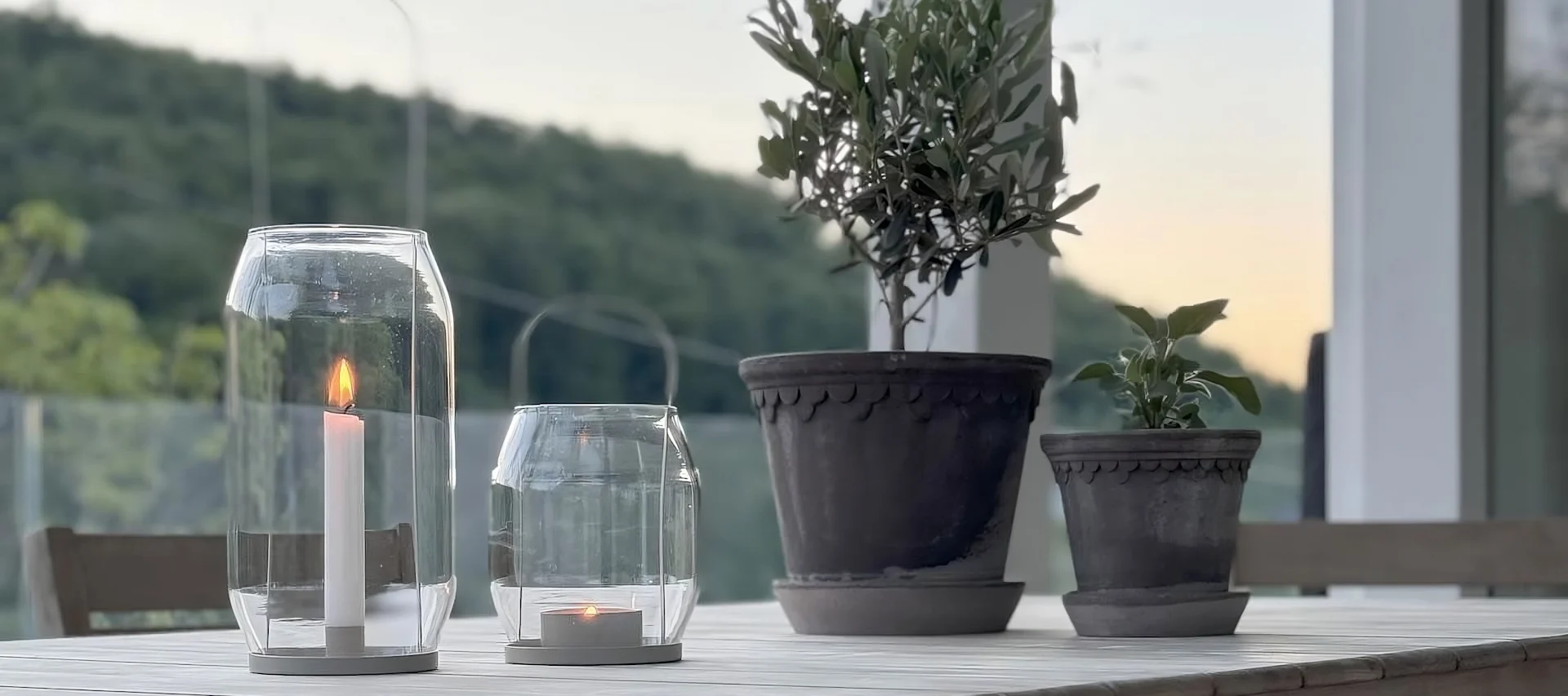 Zwei Kopenhagen-Blumentöpfe von Bergs Potter stehen auf einem Tisch, daneben zwei Ernst Laternen auf der Terrasse von @zuhauselig.