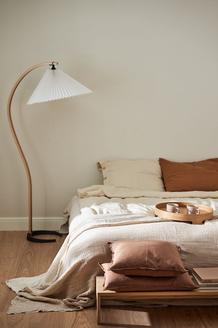 Ein Hotelfeeling im Schlafzimmer zu kreieren gehört zu dein Einrichtungstrends des Frühlings 2023. Dazu gehören luxuriöse Bettwäsche, Frühstück im Bett und eine angenehme Beleuchtung.