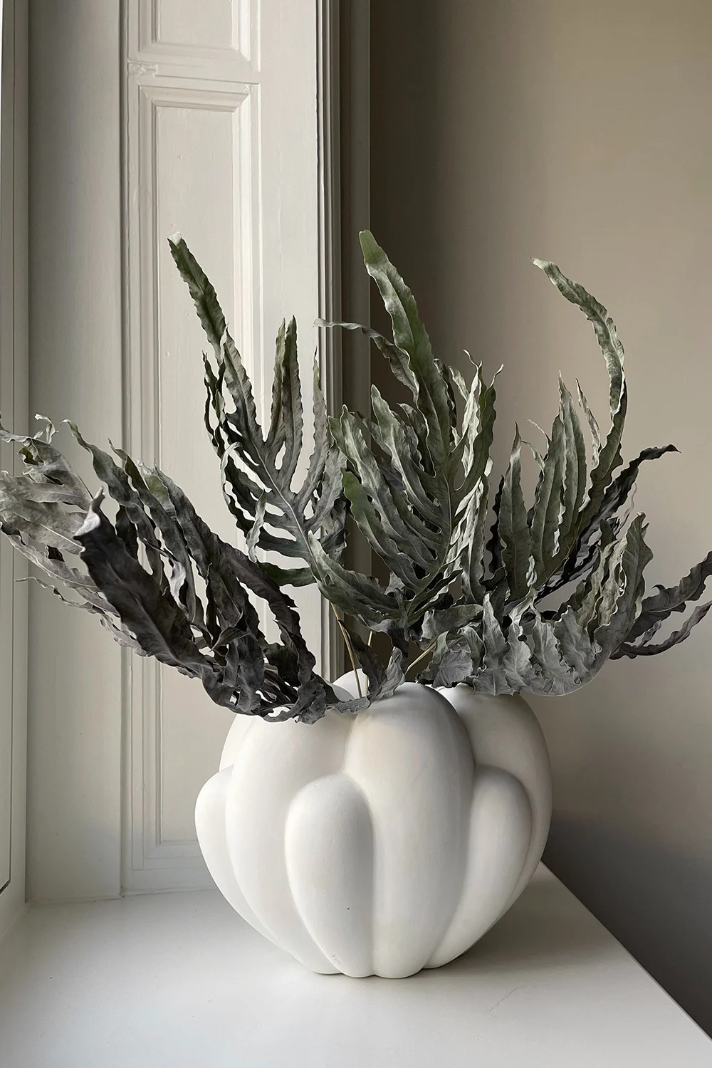 Einer der Einrichtungstrends für das Frühjahr 2024 ist der verspielte Minimalismus, bei dem eine eher neutrale Farbgebung mit aufregenden Formen, Texturen und Materialien dennoch ein lebendiges Zuhause schaffen kann. Hier die Vase Bloom in Weiß von 101 Copenhagen.