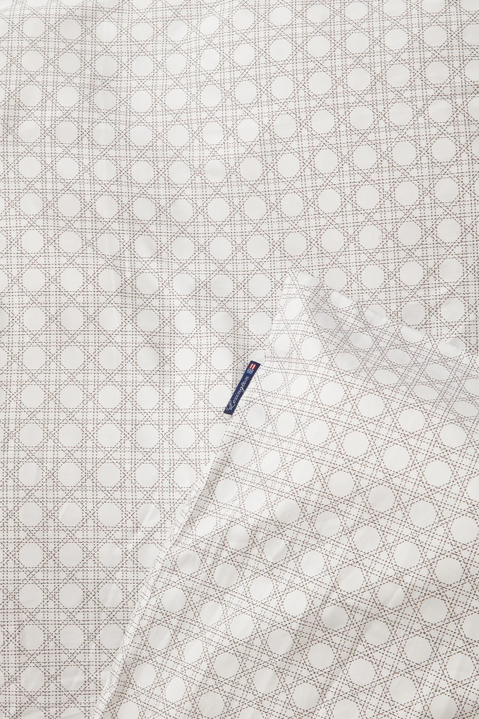 Weißer Stoff mit hellbraunem Rattanmuster und blauem Lexington-Etikett.