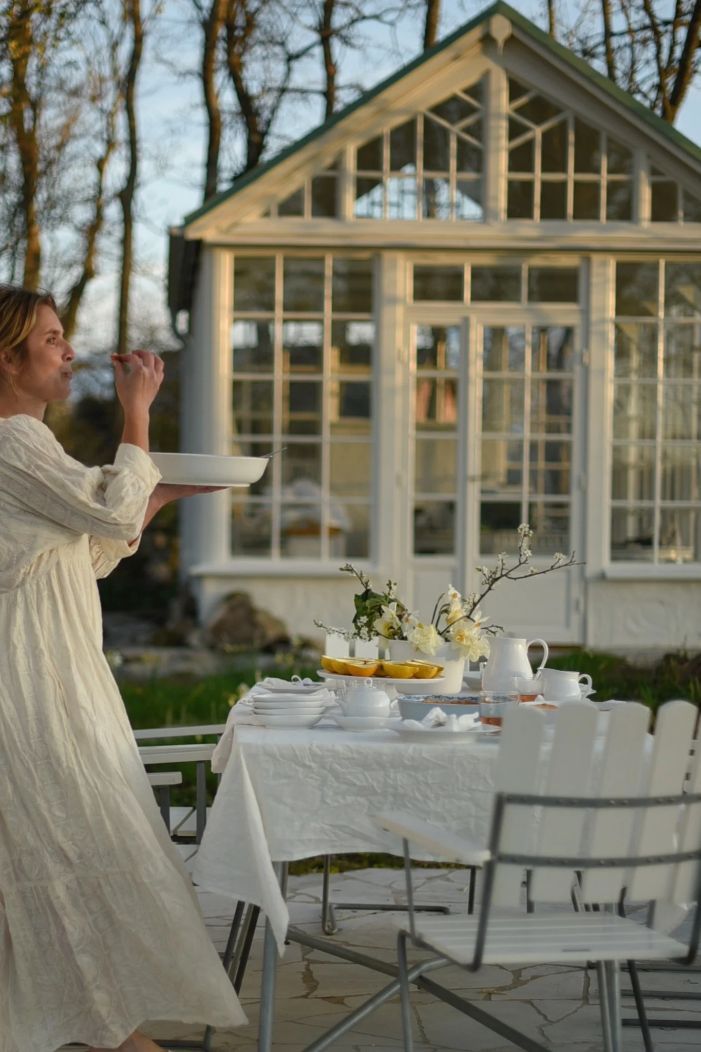Ein gedeckter Tisch mit weißen A2-Stühlen von Grythyttan steht vor einem Gewächshaus im Garten von @khouri.julia.