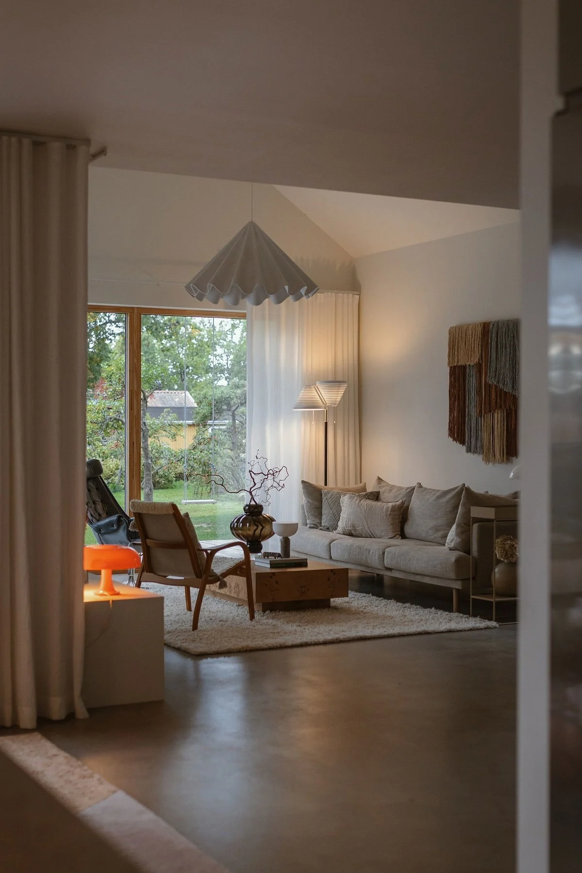 Im Wohnzimmer von Applaudden leuchtet eine orangefarbene Lampe, die die Wohntrends 2026 widerspiegelt.