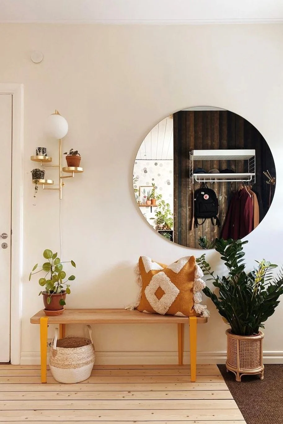 Dekorieren Sie Ihren Flur im Boho-Stil mit einer Bank, gemusterten Kissen, Pflanzen und der Astoria Wandleuchte von Globen Lighting.