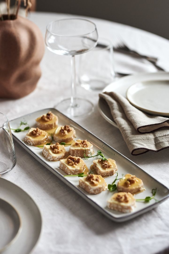 Cremiger Chevre-Ziegenkäse mit Honig und Walnüssen ist ein einfaches Vorspeisenrezept für Silvester, hier serviert auf einem rechteckigen Nordic Sand Teller.