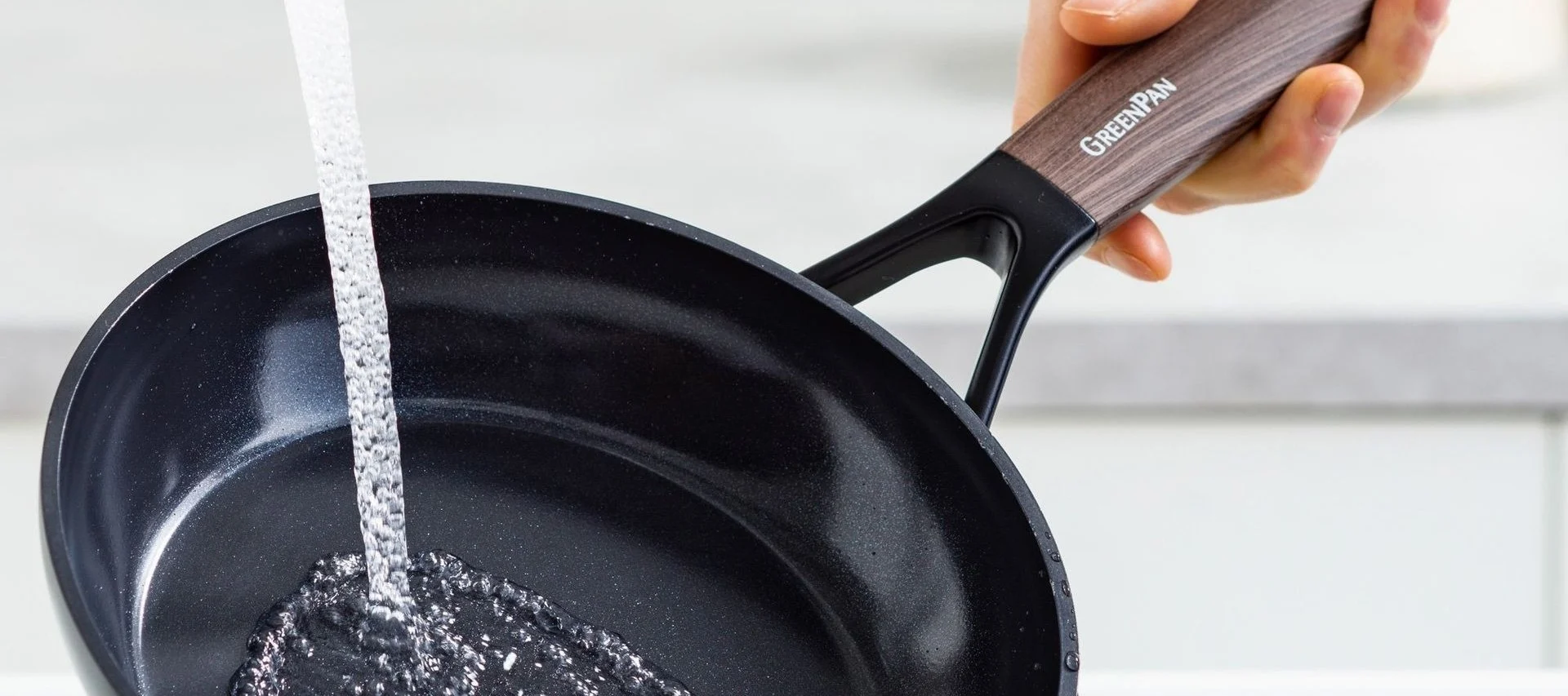 Säubern Sie Bratpfannen wie die Eco Smartshape Pfanne von Greenpan unter fließendem Wasser.