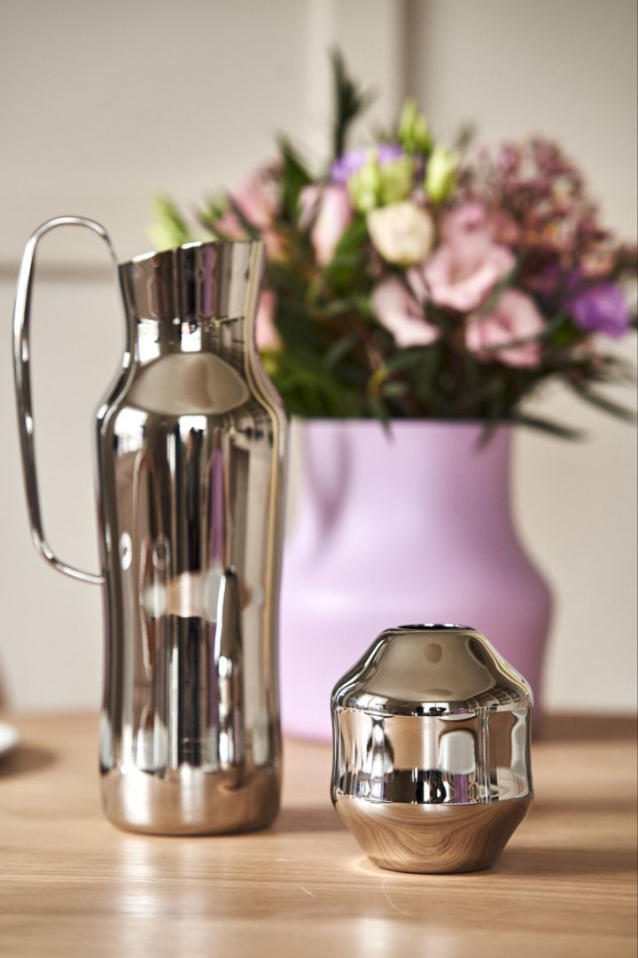 Eine Nahaufnahme der polierten Edelstahlkaraffe und der Mini-Vase Dorotea, entworfen von Monica Förster für Gense. 