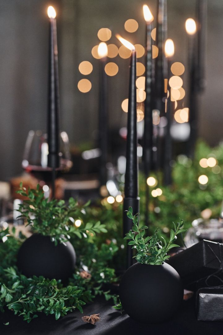 Eine dramatische Tischdeko in Schwarz: Hier sehen Sie die Cooee Design Ball Vase in Schwarz auf einem schwarz gedeckten Tisch, ideal für Halloween oder auch eine einzigartige Hochzeit.