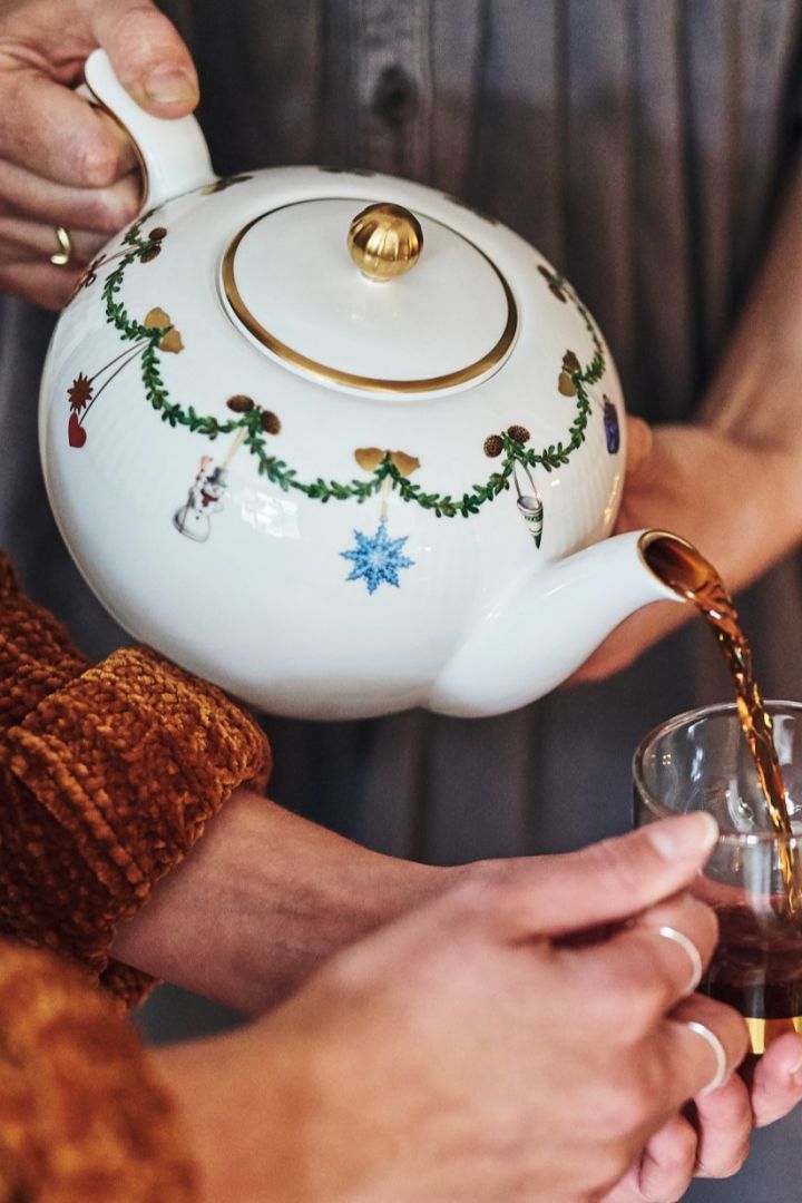 Skandinavischer Glühwein und weitere Weihnachtsrezepte: Hier sehen Sie die Star Fluted Christmas Teekanne von Royal Copenhagen, aus welcher gerade Glögg in ein Glas gegossen wird.