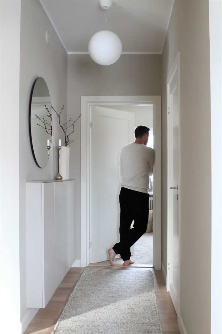 Gestalten Sie Ihren Flur: Hier sehen Sie Inspiration von @moeofsweden mit einem großen runden Spiegel, Wandstauraum und einem langen, schmalen, gemütlichen Teppich, um Platz und eine wohnliche Atmosphäre zu schaffen.