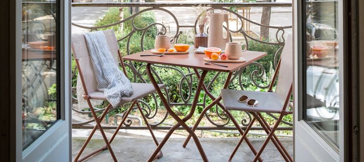 Balkonmöbel kleiner Balkon: Der Balkonstuhl von Lafuma und der dazugehörige Cafétisch bilden das perfekte Möbelset für einen kleinen Balkon, da es wenig Platz einnimmt und zusammengeklappt werden kann. Die terracottafarbenen Stahlmöbel haben einen modernen Look und sind für die meisten Balkone geeignet.