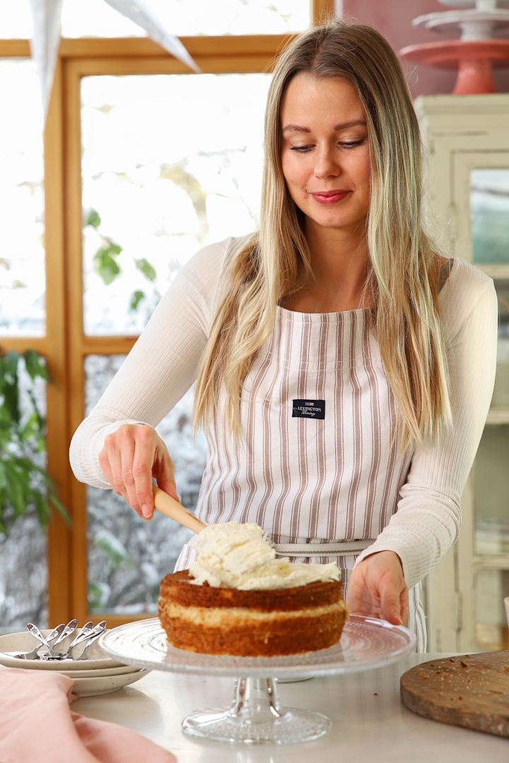 Schokodesserts für Silvester von Baka med Frida: Hier sehen Sie Frida, die die Buttercreme mit einem Teigschaber gleichmäßig auf der Torte verteilt, welche auf der Kastehelmi Tortenplatte steht.