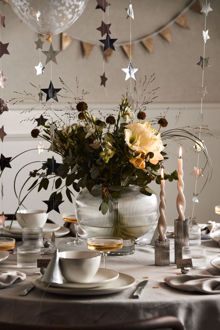 Ideen für Ihre Silvesterparty: Platzieren Sie eine große Vase mit einem Strauß Blumen darin als Blickfang mitten auf dem Tisch.