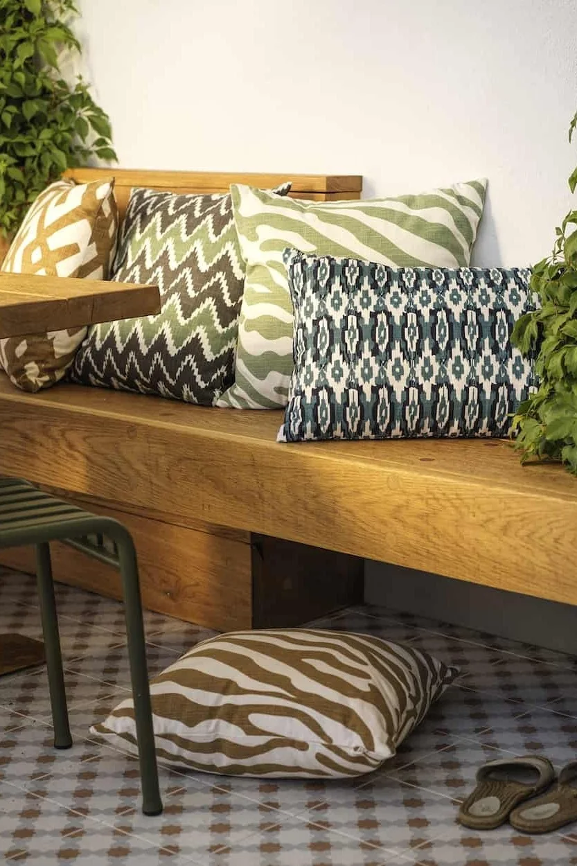 Eine große Vielfalt an Farben und Mustern sorgt für ein Boho-Gefühl. Hier sehen Sie verschiedene Kissen von Chhatwal & Jonsson auf einem Balkon im Boho-Stil.