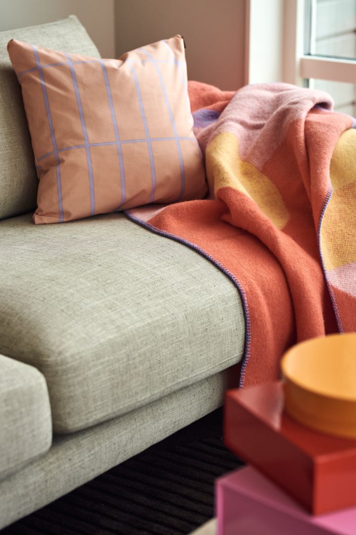 Farbenfrohe Textilien zählen zu den Einrichtungstrends des Frühlings 2023 und wir greifen diese gern mit einem Kissen von Marimekko und einer Decke von Layered auf.