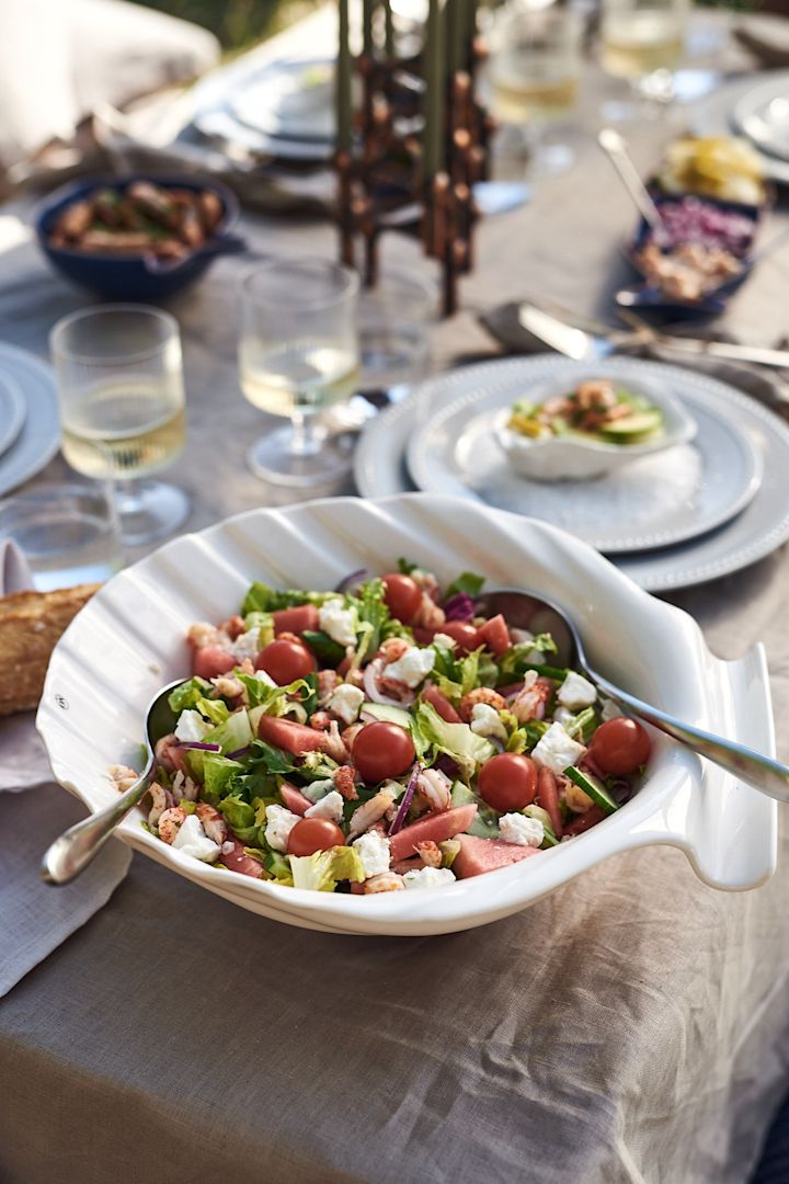 Einfaches und leckeres Sommerrezept - ein Sommersalat mit Flusskrebsschwänzen und Wassermelone, serviert in einer trendigen Muschelschale. 