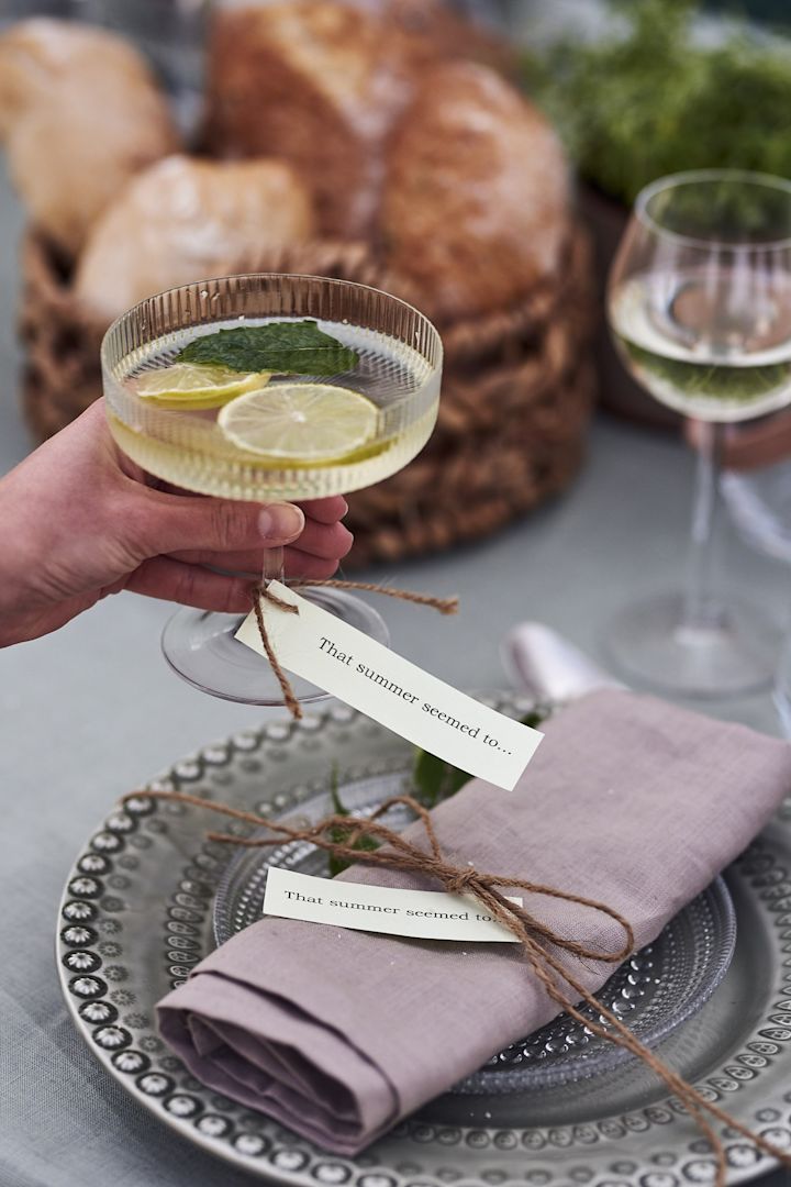 Der Tisch ist mit grünen Tellern und Sektgläsern von Ferm Living für den Mittsommer gedeckt. 