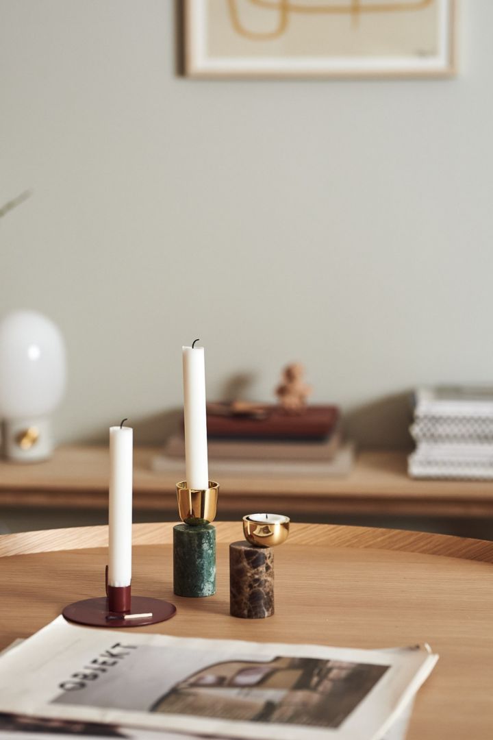 Kerzenhalter in verschiedenen Farben und Formen auf dem Couchtisch - das perfekte Stillleben.